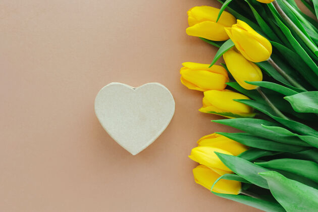 情人节黄色郁金香和米色背景的心形礼盒母亲节 情人节的背景静物 平躺礼物春天浪漫