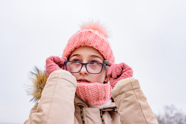 季节冬季风景中的少女肖像女孩手里拿着她的眼镜冬季肖像微笑模特快乐