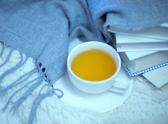 温暖床上放着一杯绿茶 一本书和一条羊毛毛毯该在家看书喝茶了热季节绿茶
