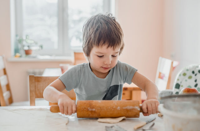 小可爱的小男孩在厨房里用擀面杖做饼干厨房准备手