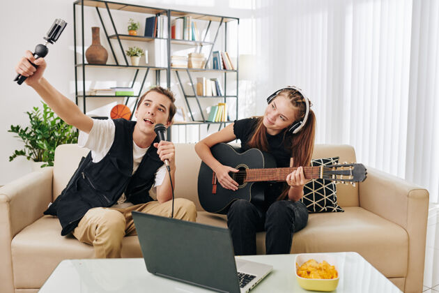 人才才华横溢的创意少年夫妇 拍摄自己唱歌和弹吉他互联网3d眼镜两个人