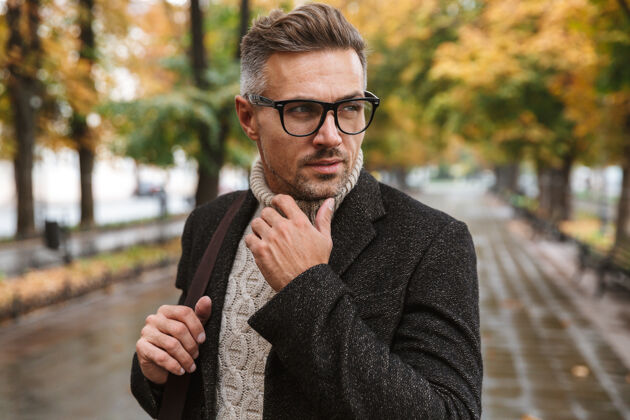 天气一张30多岁的帅哥眼镜的照片 在户外穿过秋天的公园眼镜英俊男子气概