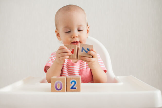 逻辑小女孩在玩木头方块 上面有明亮的数字2022游戏操场童年