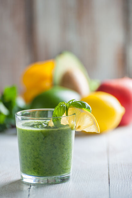 水果绿色的冰沙来自不同的蔬菜和水果在木桌上鸡尾酒健康玻璃杯