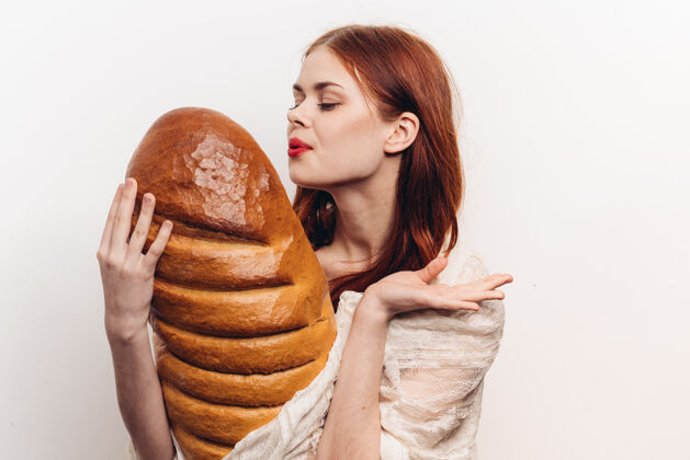 热女人手里拿着一个大面包和亮妆的轻装模特光手指面包