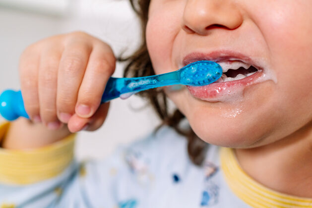 人类睡前穿着睡衣用牙刷刷牙的小孩的嘴肖像美白就寝时间