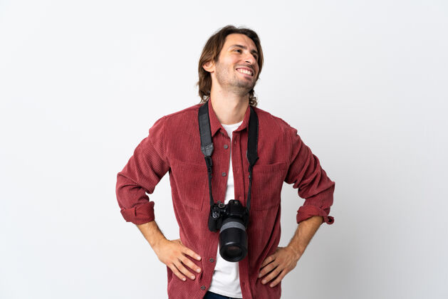 表情一个年轻的摄影师被隔离在白色的墙壁上 双臂放在臀部微笑着摆姿势男人摄影师男性
