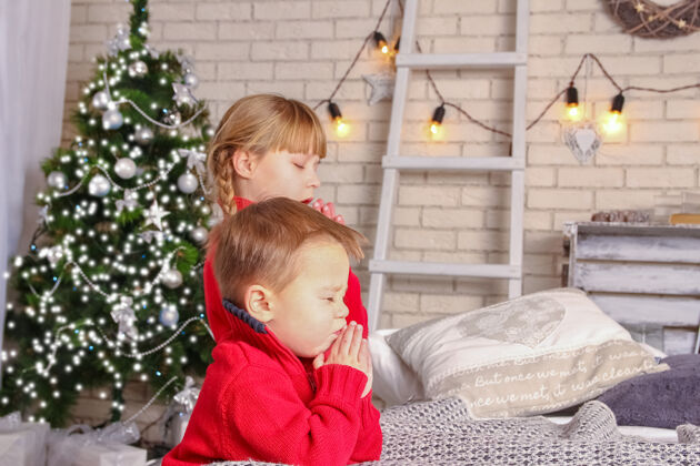 日落快乐的孩子们在家里为圣诞节祈祷上帝白天春天