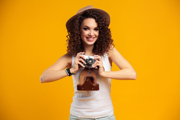季节在明亮黄色的复古相机上拍摄的笑脸少女肖像笑头发女性