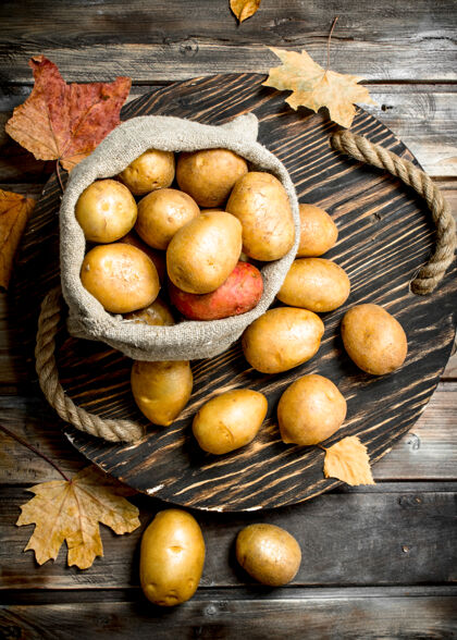 食用把土豆装在一个袋子里放在托盘上离开开木桌农产品农业生的