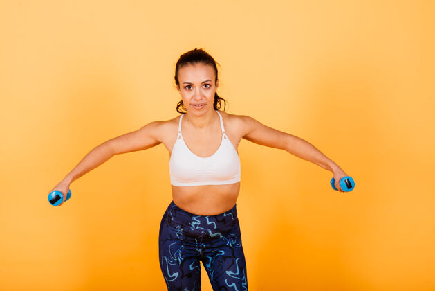 健身强度和动机完全穿着运动服的年轻苗条的非洲妇女在黄色背景下的工作室里锻炼身体的长度人运动员减肥