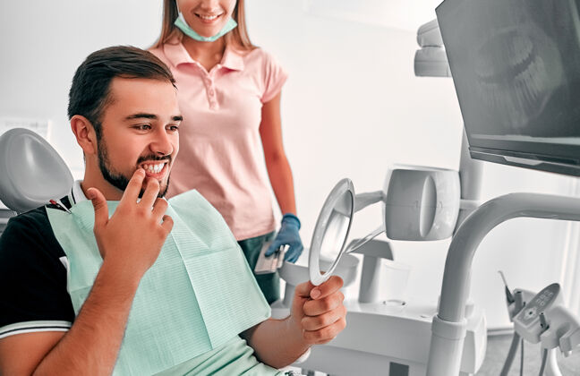 修复检查牙齿的人男镜去看牙医办公室男牙医办公室的病人 显示哪些牙齿需要修复牙齿正畸医生健康