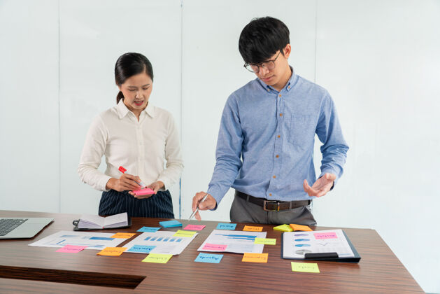 职位商人在桌上贴上五颜六色的便条 讨论新项目 分享想法 思考如何策划新案例墙壁技术数据