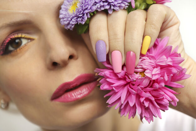 人造指甲粉蝶女孩的长指甲上的妆容和美甲指甲艺术紫菀指甲