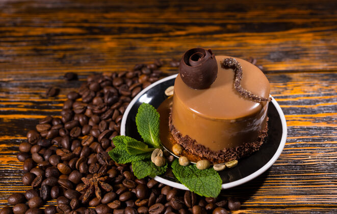 烤美味的小圆筒形巧克力蛋糕片在盘子里被咖啡豆包围在深色的木制背景上口味自助餐厅爪哇