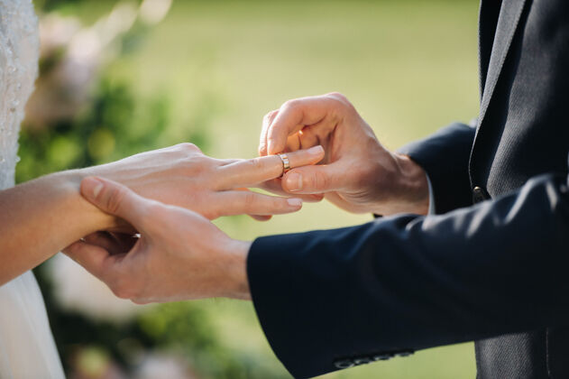 情侣婚礼当天新郎把订婚戒指戴在新娘的手指上求婚手婚礼