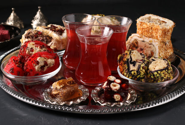 水果土耳其喜悦和石榴茶的金属托盘上黑暗的表面 特写 水平格式美味杯子喜悦