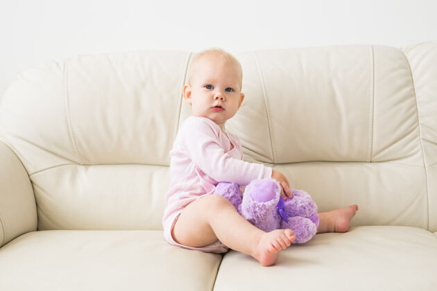 赤脚儿童 童年和儿童概念-沙发上迷人的女婴画像孩子婴儿幼儿