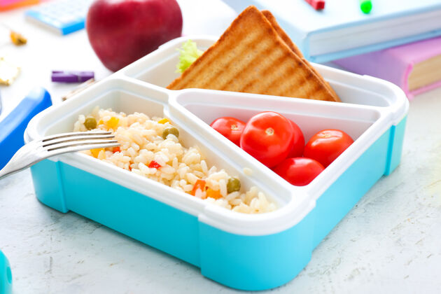 塑料桌上摆着美味的学校午餐盒健康盒子学生