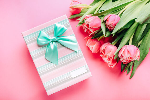 明亮礼盒和一束美丽的郁金香在粉红色装饰郁金香花