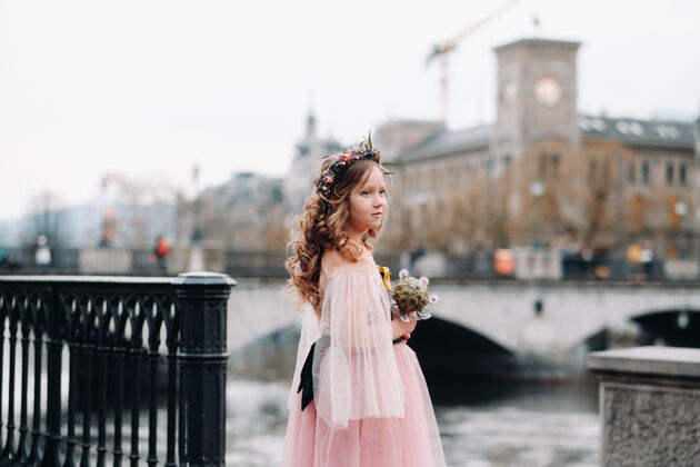乐趣一个穿着粉色公主裙的小女孩手里拿着一束花束 走在巴黎古城苏黎世肖像一个穿着粉色裙子的女孩在瑞士的城市街道上花女孩衣服