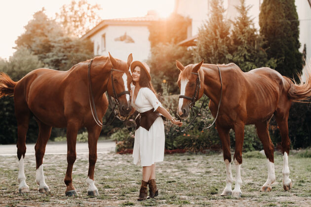 农场在大自然中 一个戴帽子的女孩站在马旁边欢乐时尚女孩休闲