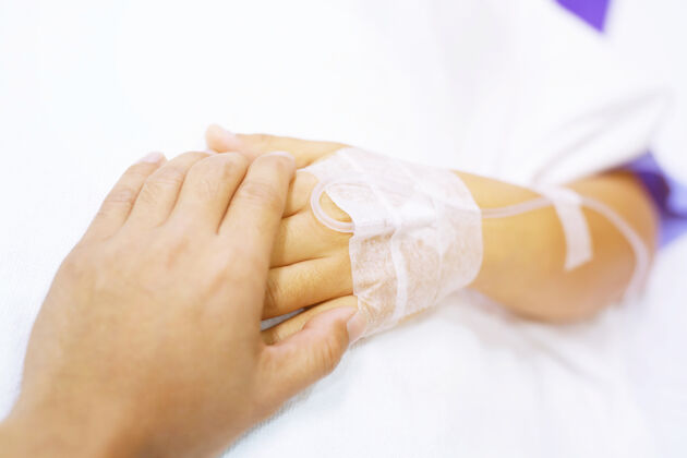 诊所特写镜头聚焦在病床上与病人握手鼓励病床上的鼓励病床护士握手