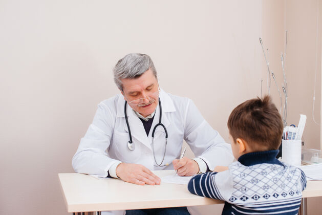 健康一个小男孩在一个现代化的诊所里被一位经验丰富的医生倾听和治疗一种病毒 一种流行病流行临床医生喉咙