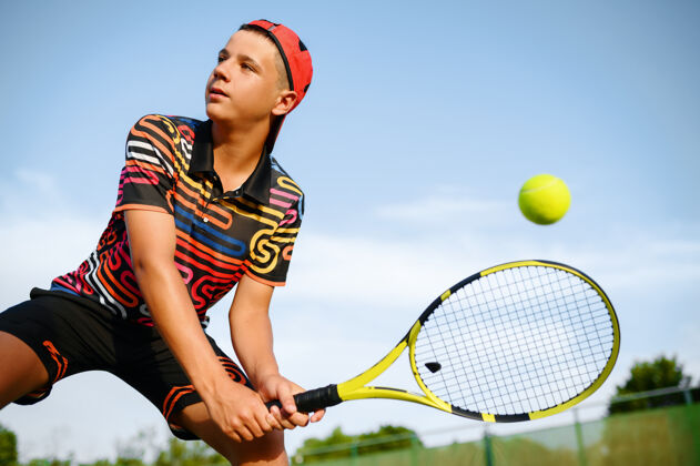 网年轻的男子网球运动员用球拍在室外场地击球 击球动作.激活健康的生活方式 体育比赛 球拍健身训练人娱乐球