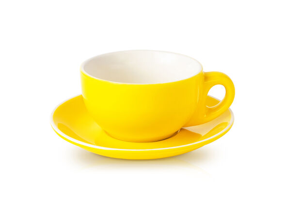 空空的黄色茶杯与茶托隔离在白色餐具瓷器影子