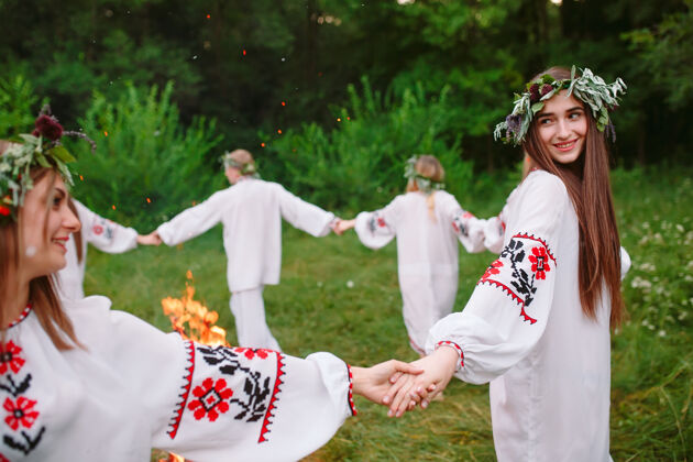 烟仲夏年轻穿着斯拉夫人衣服的人在盛夏围着火转女性仪式火