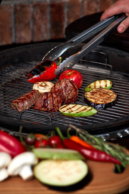 户外蔬菜和肉在烤架上发出咝咝声木炭迷迭香烹饪