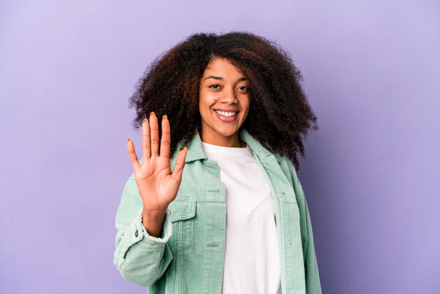 总计年轻的非洲裔美国卷发女子孤立在紫色的微笑欢快显示数字五与手指非裔美国人显示非洲