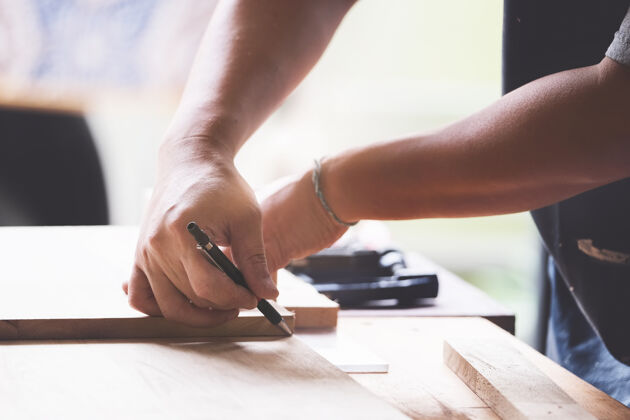 修理工一个木匠测量木板来组装零件 并为客户搭建一张木桌人工人职业