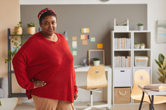 工作一个穿着休闲服的胖女人站在办公室里看着前面的画像人物自信休闲服