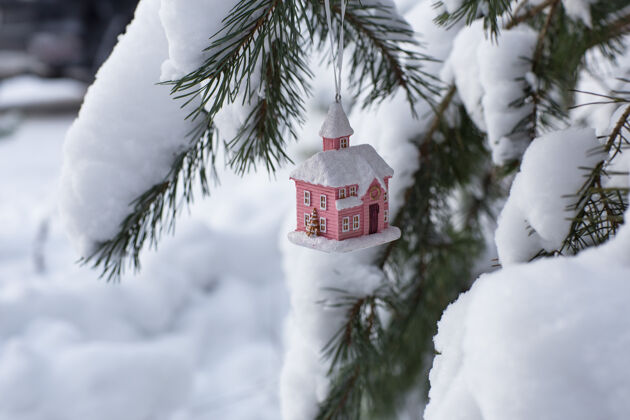 霜冻房子挂在云杉枝上自然小圣诞节