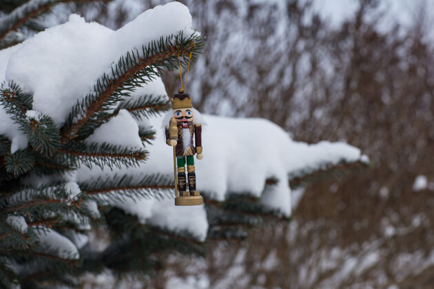 霜冻胡桃夹子挂在云杉枝上户外冬天木头
