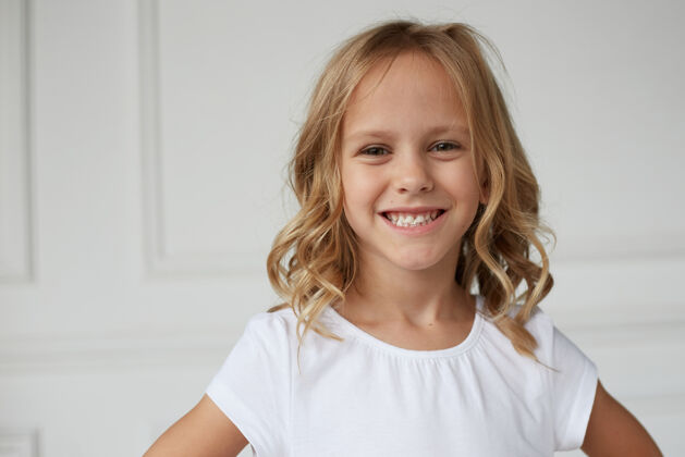 孩子一个可爱的微笑的小女孩展示她的牙齿嚼口香糖的特写镜头小女孩姿势