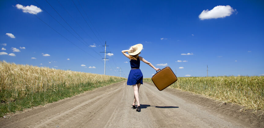 成人乡间小路上带着手提箱的孤独女孩屈服包道路