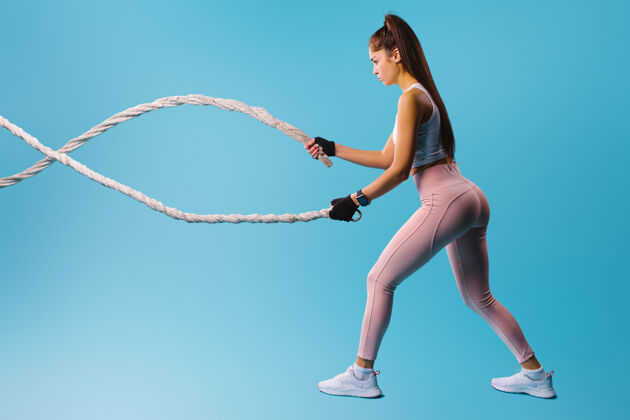 锻炼穿蓝色运动服的运动女孩背景.运动健康的生活方式理念健身房绳索时尚模特