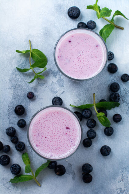 晚餐新鲜健康的蓝莓 冰沙 浆果和薄荷放在浅白色的混凝土表面上甜点素食者酸奶