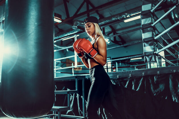拳击手漂亮的女拳击手通过打拳击袋训练拳击手拳击运动