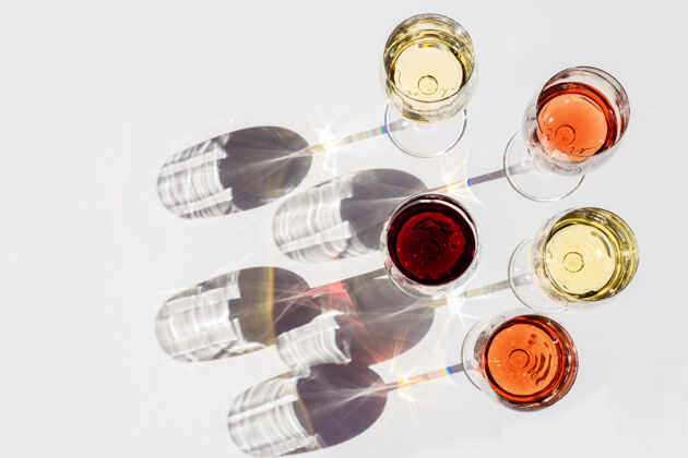 玻璃器皿红 玫瑰和白葡萄酒在阳光下俯瞰日光色调味道