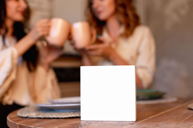 干净咖啡店的白色空白盘子里有两个女人厨房名牌特写