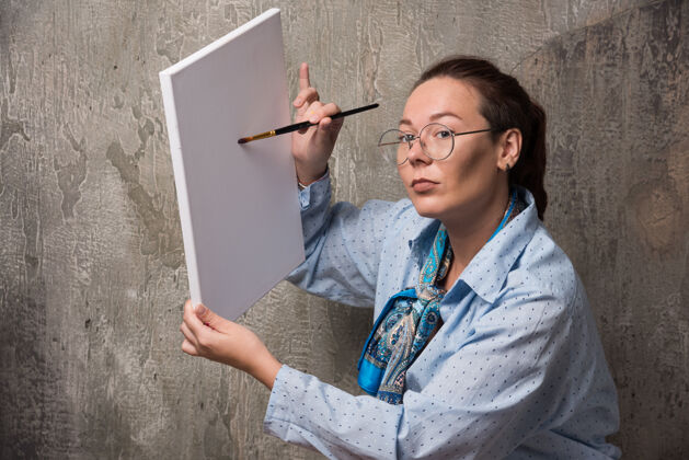 工艺女艺术家用画笔在大理石上展示她的画布艺术家手爱好