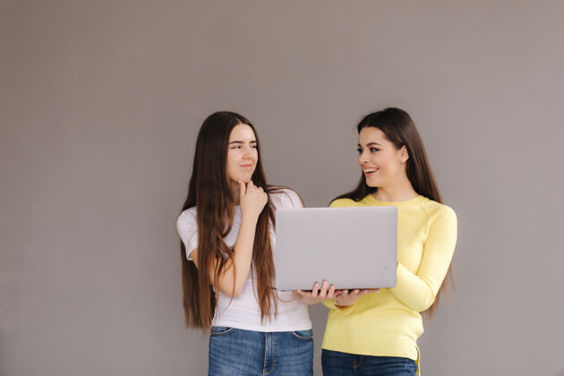 概念两个女人抱一个女士笔记本电脑互相看看手情感毛衣