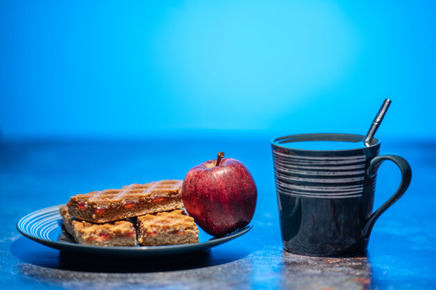 甜点桌上放着一杯茶 一盘饼干和苹果自制厨房派