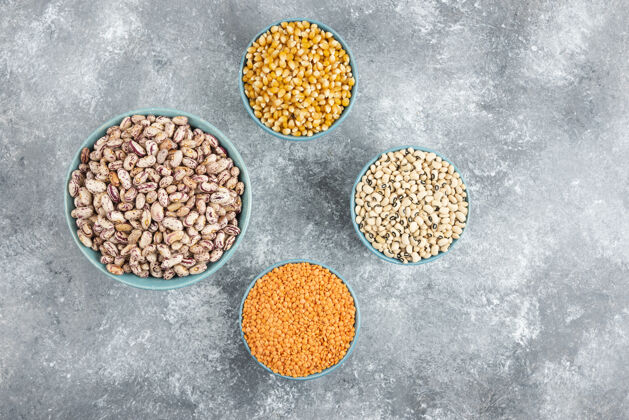 干的一碗碗生豆子 小扁豆和玉米放在大理石表面碗堆玉米