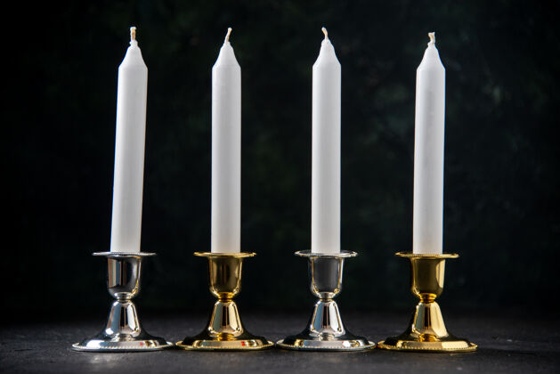 葬礼前面的白色蜡烛在金色和银色的立场上黑色银死亡光
