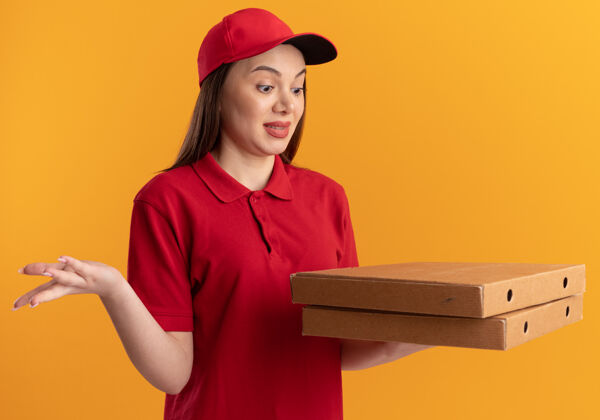 制服穿着制服的漂亮送货员兴奋地抱着比萨饼盒看盒子披萨送货